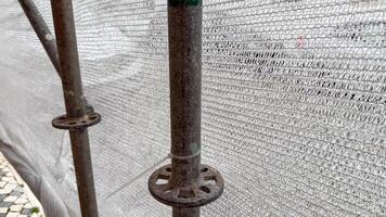 Rust kissed scaffolding pole, whispers of urban renewal, echoes of labor, reminiscent of Labor Day and Silent Work Day photo