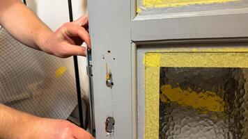 Craftsmans hands attend to aging door, rustic DIY restoration, embodying nostalgic charm, vital home repair, Fix a Leak Week photo
