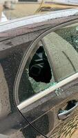 Shattered window whispers urban mystery, shards glistening like stars, unexpected tales for Nuit Blanche or Car Security Awareness Week photo