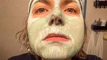 A Caucasian womans face, adorned with a cracked mint mask, echoes self care rituals and World Spa Wellness Day photo