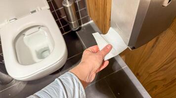 A hand reaches for toilet paper in a zen like restroom, evoking Global Handwashing Day and Hygge home rituals photo