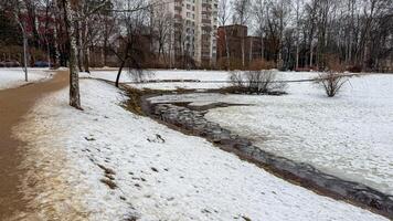 Serpentine whispers of thawing snow cradle winding stream in urban tundra, perfect for Slavic Maslenitsa festivities photo