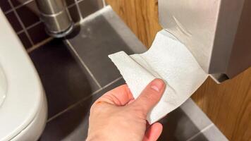 A hand reaches for textured paper, evoking Hygges cozy rituals, nestled by Oktoberfests charming practicalities, in a Nordic washroom photo