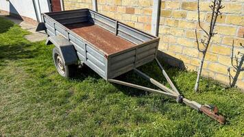 Rustic metal trailer basks in spring sunlight, hinting at whimsical backyard projects or Dia de la Cosecha festivities photo