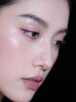 A close up of a woman with glitter on her face photo