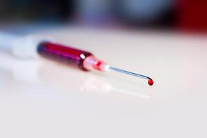 Syringe needle with blood macro view photo
