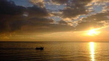 A boat is out on the ocean at sunset video