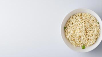 Freshly cooked instant noodles with green onion garnishes in a white bowl on a clean white background perfect for Asian cuisine food images and quick meal concepts photo