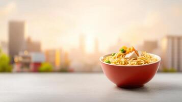 Freshly cooked instant noodles in a red bowl placed on a rooftop with a city skyline in the background du sunset photo