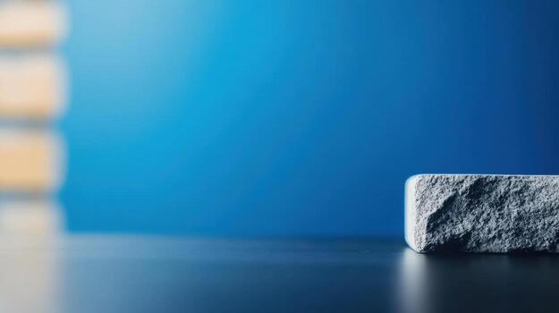 Minimalist Still Life with Rough Concrete Block on Smooth Surface Against Bright Blue Background for Modern Design and Artistic Photography Composition photo