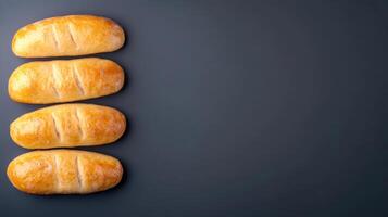 Freshly baked croissants with golden crust and flaky layers placed in a vertical line on a dark background with space for text or decoration photo