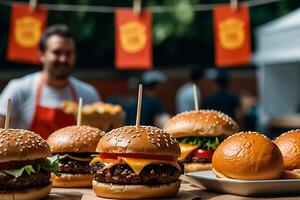 A man is standing in front of a table with hamburgers photo