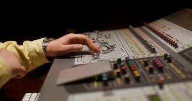 Sound engineer uses an audio mixer while recording a song in the studio. photo
