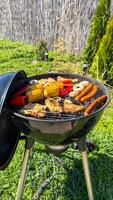 Sizzling grill symphony of corn, peppers, and sausages evokes midsummer picnics and eccentricity of Garden Gnome Day celebrations photo