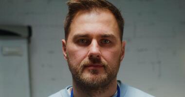 Handsome young man of European appearance with a short beard smiling looking straight into the camera, close up of a male face photo