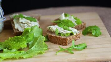 Slice of rye bread with cheese spread and greens on the table video
