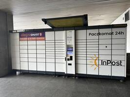 Warsaw, Poland - May 22, 2025 InPost automated parcel locker system with multiple compartments for package delivery, located in a modern urban setting, showcasing convenience and technology photo