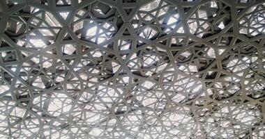 Abu Dhabi, UAE, 2025 - Close up of the openwork dome of the Abu Dhabi Museum of Art in Dubai. The camera is spinning photo