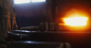 The hammer lies on the anvil in the blacksmith's workshop, close up, no people. Details of the working process of forging iron. 4k , red komodo photo