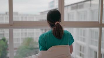 A moment of reflection. The girl pauses and looks out the window, giving a touching moment of self reflection. Seeing a comforting and thought provoking image. video