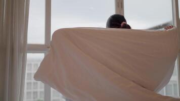 Staring contemplatively at the window A person is wrapped in a cozy blanket and staring contemplatively at the cityscape through the window, reminiscing about self reflection. video