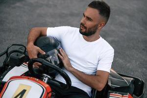 Handsome positive ,,man ,is ,outdoors, kart racing conception photo