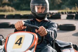 Front view, driving,. Man is outdoors, kart racing conception photo