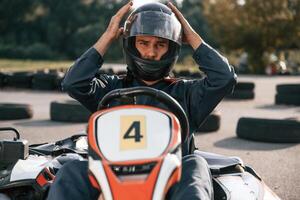 Front view, driving. Man is ,,,outdoors, kart racing conception photo