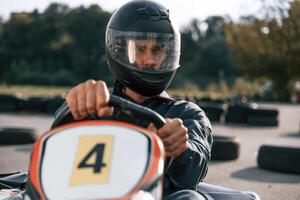 Front ,view, driving. Man is outdoors,,, kart,, racing conception photo