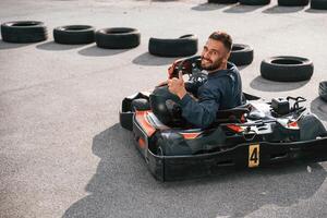 Riding and looking behind... Man ,,is outdoors, kart racing conception photo