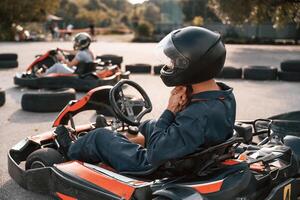 Side view, wearing the safety helmet. ..,Man is outdoors, kart racing conception photo