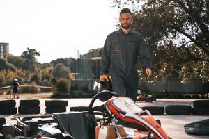 Walking ,by, the ,vehicle. Man is outdoors, kart racing conception photo