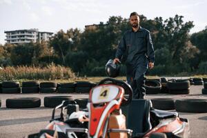 Walking, by the vehicle. Man is outdoors, kart racing conception photo