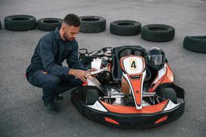 With notepad ,in hands. Man is outdoors, kart racing conception photo
