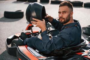 Riding, and, looking behind. Man is outdoors, kart racing conception photo
