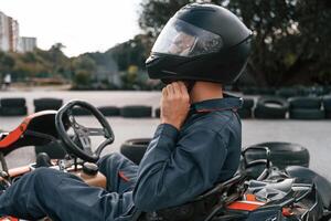 Side ,view, wearing the safety helmet. Man is outdoors, kart racing conception photo
