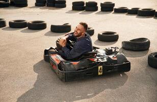 Looks, behind while riding. Man is outdoors, kart racing conception photo