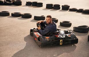 Looks,, behind while riding. Man is outdoors, kart racing conception photo