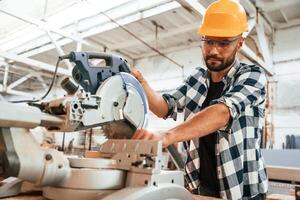 Focused, woodworking. Man is,, in, warehouse photo