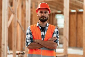 Standing with, arms crossed. Industrial worker in wooden warehouse photo
