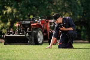 Touching ,,the, grass, quality ,control. Man is with utility tractor with grass cutter and aerator equipment on the field photo