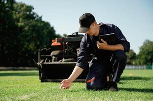 Quality, control, touching ,the grass. Man is with utility tractor with grass cutter and aerator equipment on the field photo