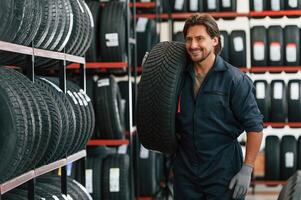 Moving the tire. Man is in the tire fitting car ,,,service photo