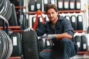Front ,view,,new ,wheel. Man is in the tire fitting car service photo