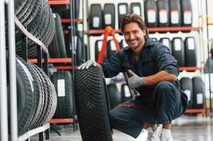 Time ,for replacement. Man is in, the tire fitting car service photo