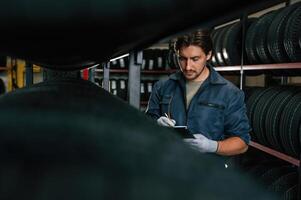 Work, in,, progress, manager, is in warehouse. Man is in the tire fitting car service photo
