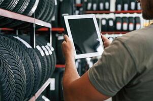 Copy space ,,on ,the digital tablet. Man is in the tire fitting car service photo