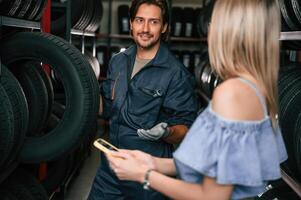 Woman ,is, in, the tire fitting auto shop with worker photo