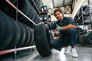 Positive, facial ,,,expression. Man is in the tire fitting car service photo