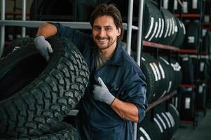 Professional, worker is,, with wheel. Man is in the tire fitting car service photo